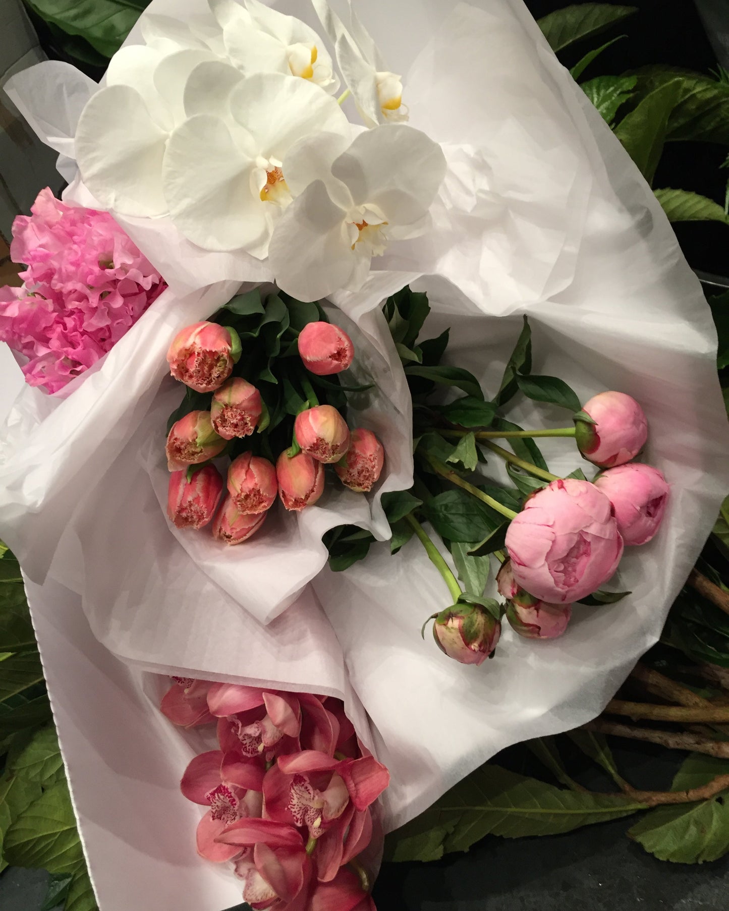 stunning floral house arrangements pink sweet peas, ruffle tulips, pink peonies and pink and white orchards